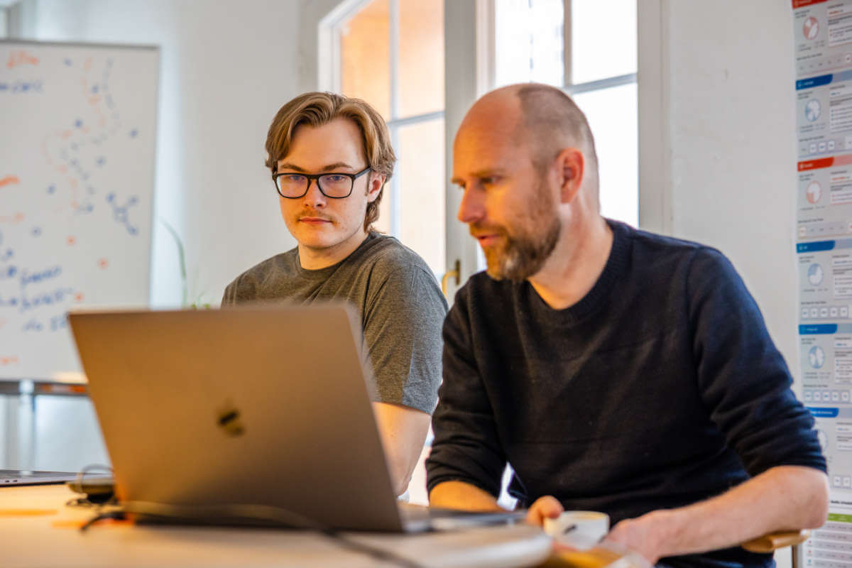 To kollegaer ved en bærbar computer